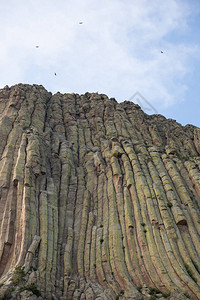 在怀俄明形成魔鬼塔纪念碑的惊人的垂直岩石柱与云层相对立环绕图片