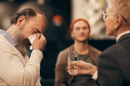 年长留胡子的男子在开会时与成熟女人一起喝水图片