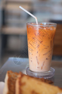 用稻草装在玻璃杯中的冰奶茶或泰式奶茶图片