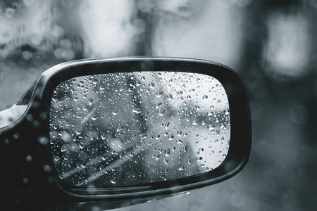 通过汽车挡风玻璃上的雨滴看到城市道路图片