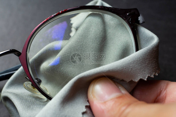 妇女右手用显微纤维清洁布清洗短视或近视眼镜图片