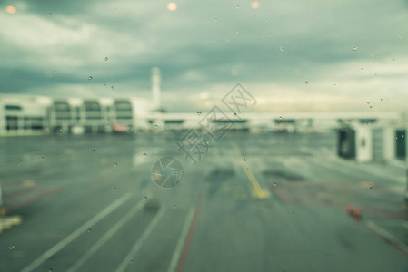 机场窗户的雨滴东南亚季风节的雨滴飞机失明和航站楼交图片