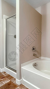 垂直框架浴缸和浴室内有玻璃门的淋浴摊子图片