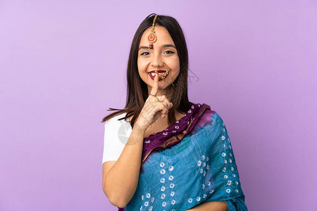 在紫色背景中被孤立的年轻印度女表现出沉默的手势将图片