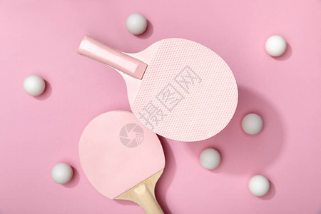 粉红色背景中白色乒乓球和拍的顶部视图背景图片