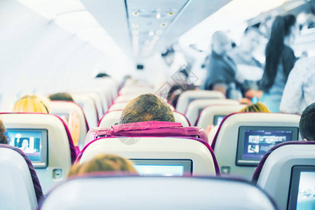 国内飞机内有乘客坐在座位上并走在过道上等图片