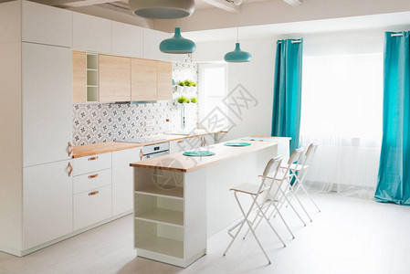 现代白色厨柜与电磁炉打开有白色家具的明亮的厨房岛厨房绿松石灯和窗帘现代明图片