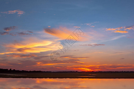 日落倒影泻湖在云层和蓝天之上的泻湖景观背景之上的美丽日落日落时有云图片