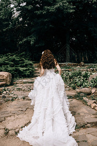 美丽的新娘站在她身后穿着婚纱穿上蕾丝带快乐图片