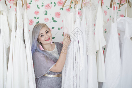 亚洲妇女婚纱店主负责照顾自己的产品女图片