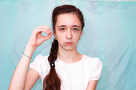 一个留着长辫子的女孩用手聋哑人的手语展示字母o中等计划图片