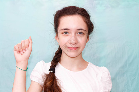 一个留着长辫子的女孩用手聋哑人的手语展示字母A中等计划图片