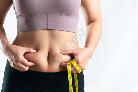 肥胖的女人手握着过多的腹部脂肪图片