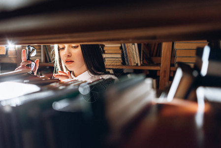 青少年女孩在图书馆里选择书籍图片