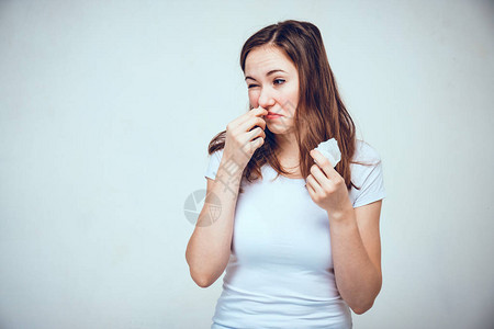 穿白色T恤的女生正在测试不同的药剂来治疗一个闷鼻子图片