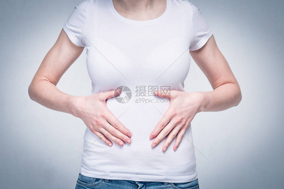 身穿白色T恤的女童因食物贫乏和营养不良而胃部和胃部疼痛图片