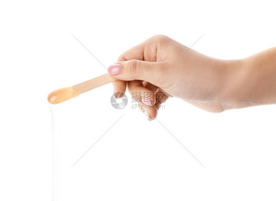 白色背景下用糖浆粘在棍子上的女手图片