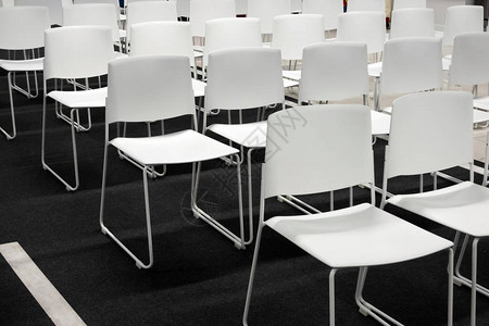 用于正式会议会议讲座毕业典礼的一排白色塑料椅子房间里摆满了空荡背景图片