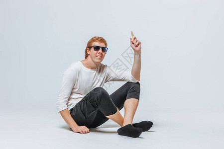 红发男子戴太阳镜白色T恤衫和黑短裤图片