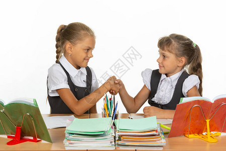 桌边的两个女孩握手图片