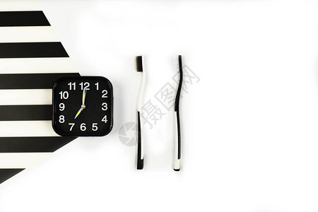 黑色闹钟与手动牙刷设置在白色和黑色背景牙刷有两种颜色牙齿健康图片