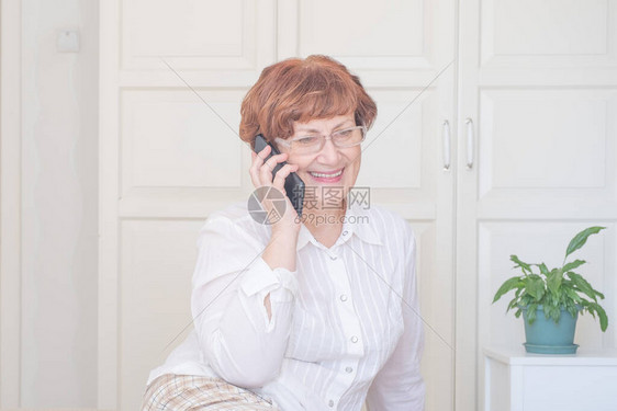 在家用手机说话的年长妇女人际联系通讯生活方式时图片