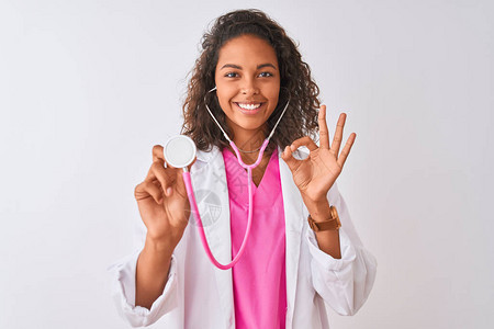 使用听诊器站在孤立的白色背景上站立的年轻巴西女医生图片