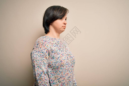 身处孤立背景的年轻综合症妇女站立一旁图片