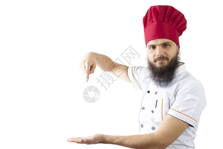 厨师用食指向手掌上的空白处有胡子的男厨师在一个红色的帽子和孤立的白色背景上的白衬衫微笑在脸上复制广告图片