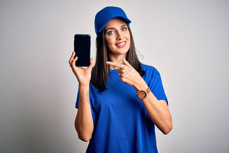 蓝眼睛戴着帽子拿着智能手机的年轻送货员非常高兴地用图片