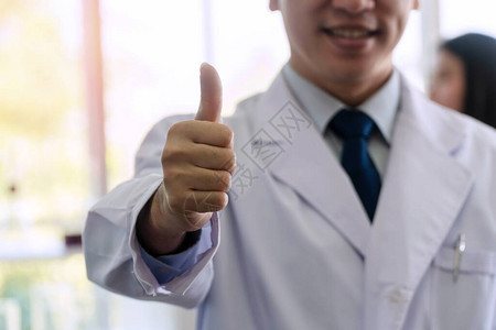 白衣医生的手和笔在医院工作成功时举起拇指图片