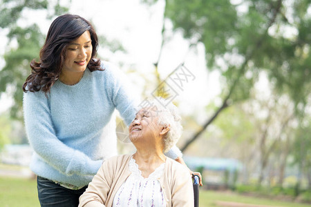 帮助和照顾护理医院公园坐在轮椅上的亚洲老年或老年妇人患者图片