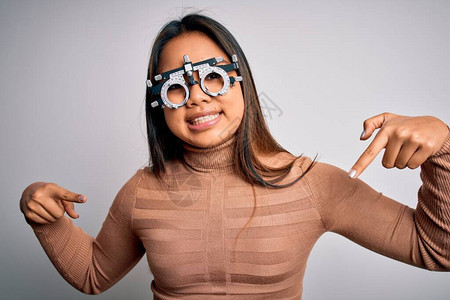 年轻的亚洲光学女孩在白色背景下使用验光眼镜控制视力图片