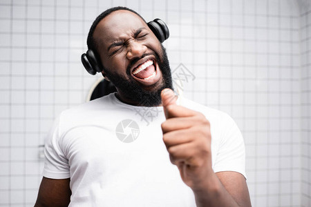 非洲裔美国人戴着耳机在牙刷里唱歌图片