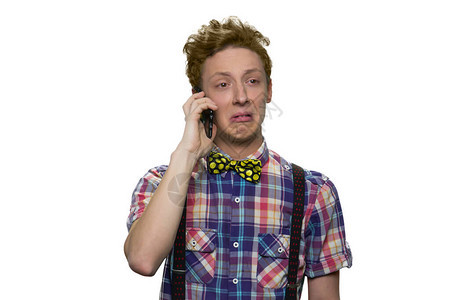 年轻男孩的肖像在电话上讲着面部厌恶的表情图片