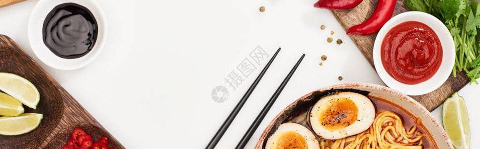 白色表面新鲜成份和筷子旁的辣椒拉面图片