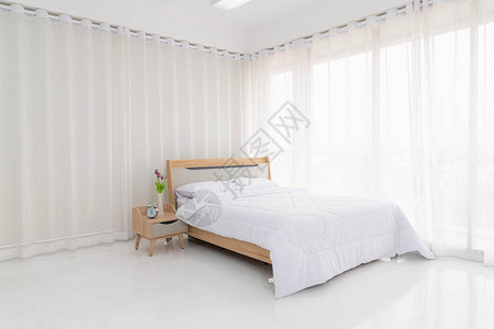 室内白色卧室配有白色窗帘和白色枕头图片