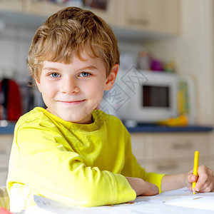 可爱的学校孩子男孩在家做作业的画像小集中的孩子用彩色铅笔在室内写字小学和教育孩子图片