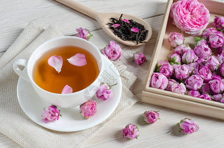 一杯茶玫瑰花和木勺子图片