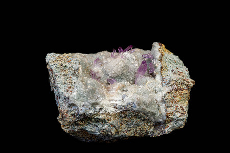 黑色背景特写岩石中的宏观矿物紫水晶石图片