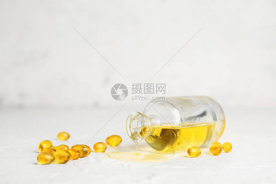 白色背景中的一瓶鱼油和药丸图片