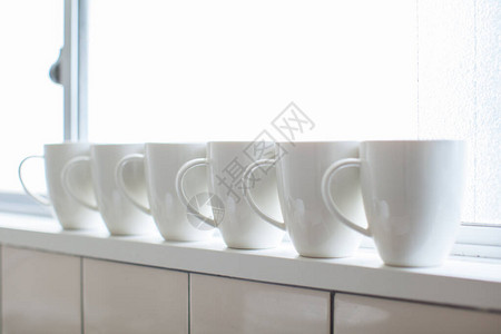 导播室白色咖啡杯排在住宅室窗户附近的背景