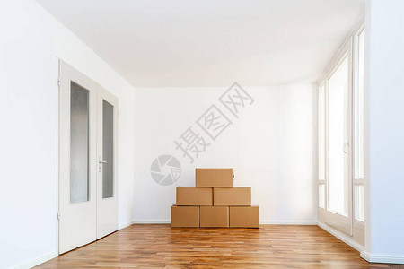 在空荡的公寓里靠着白墙移动箱子图片
