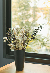 黑色花瓶中美丽的干鲜花束有玻璃窗图片