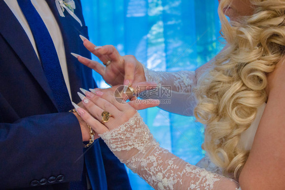 新娘将结婚戒指戴在无名指上新娘和新郎的婚礼在婚礼图片