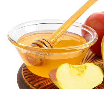 白色背景上的一碗新鲜蜂蜜和苹果图片