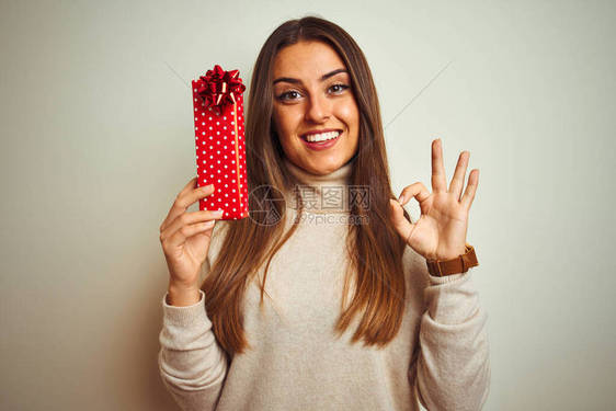 年轻美女拿着情人节礼物在孤立的白色背景上站立手举足轻重图片