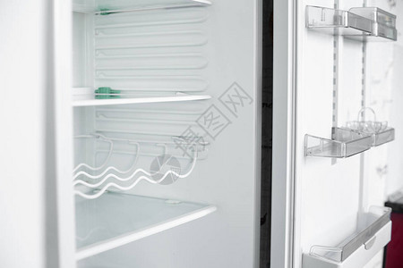呆在家里的空冰箱的前视图没有蔬菜和水果的白色现代冰箱在房子里有几个架子的电冰箱电器和图片