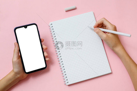 右手在笔记本页上挂有笔左手持有空白显示的移动电话请查看InfoFin图片