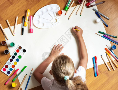 小女孩在家中地板上用纸笔画彩色笔背景图片